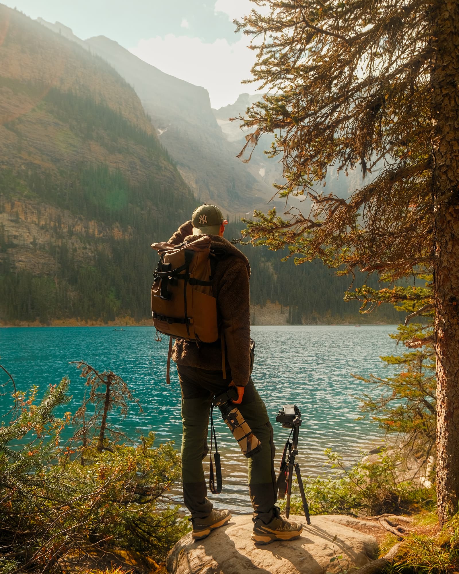 Téo Prunier-Meline with his camera and tripod beside a mountain lake